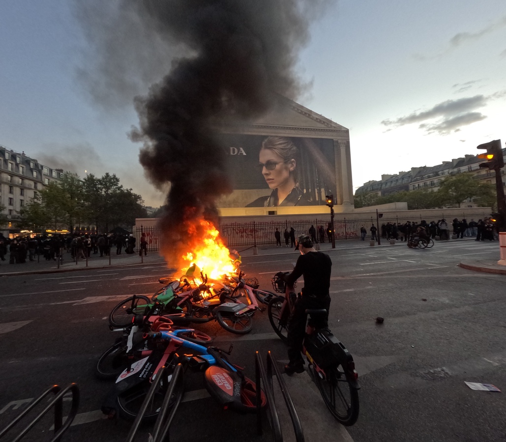 Mais quelques mètres plus loin, une autre brûle à l'arrière de l'église de la Madeleine - Le contraste avec la pub Prada est saisissant - © Reflets