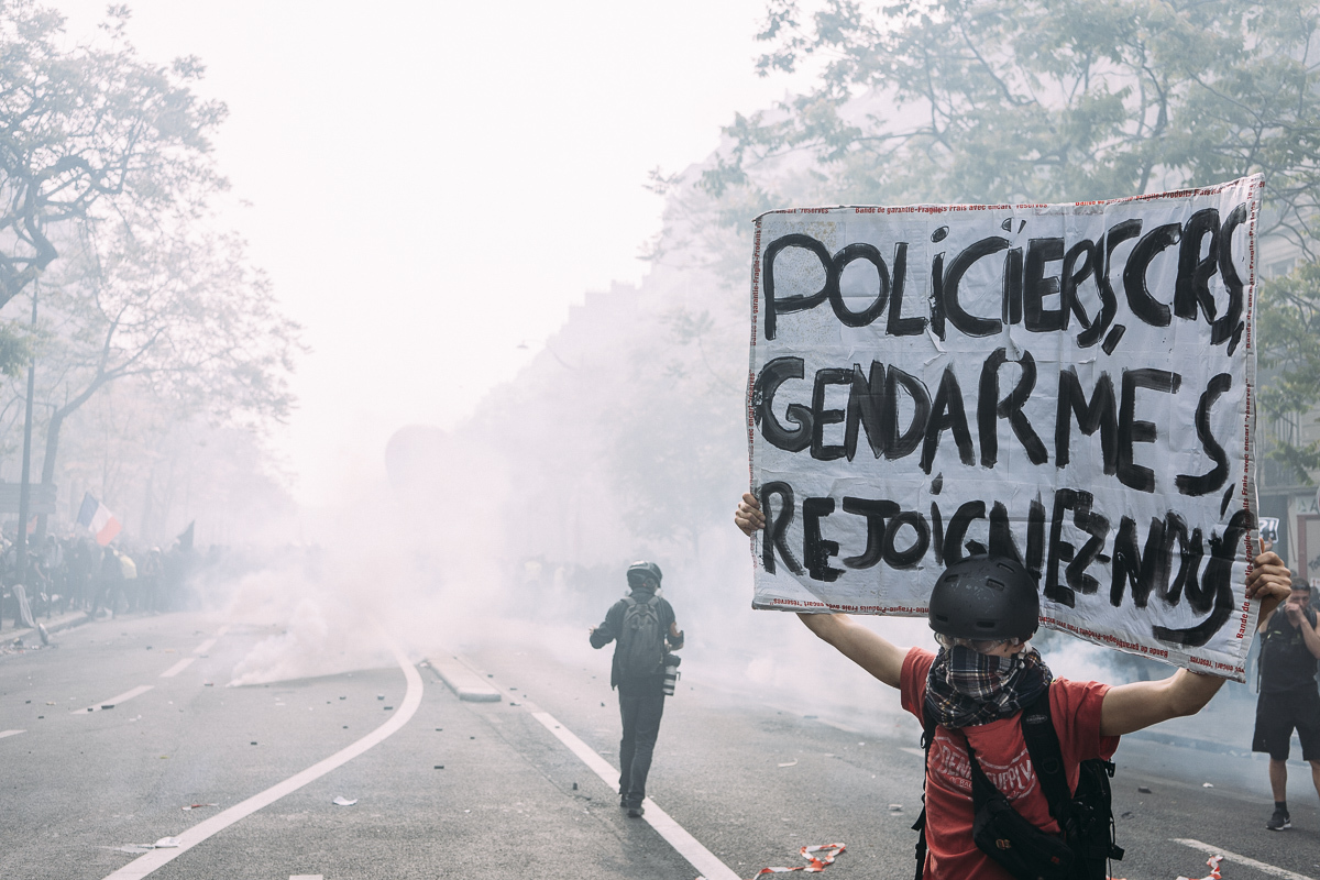 Un manifestant brandit une pancarte « Policiers, CRS, gendarmes, rejoignez-nous ».  - © Denis Meyer