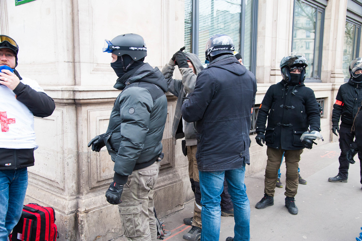 Petite fouille aux alentours de la mairie de Paris. Confiscation des masques à gaz. Deux sans-papiers sont contrôlés au passage. Les policiers les laissent partir. - © Reflets