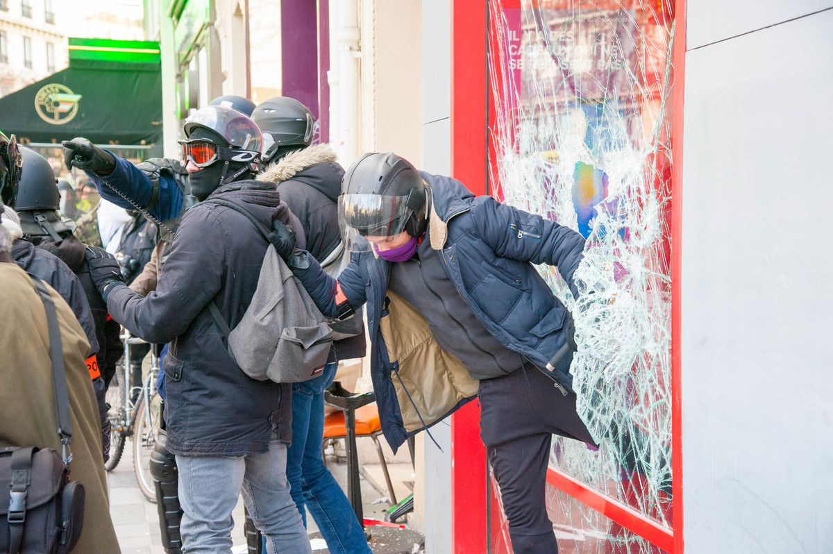 Des policiers s'assurent qu'il n'y a personne à l'intérieur d'une boutique SFR vandalisée - © Reflets