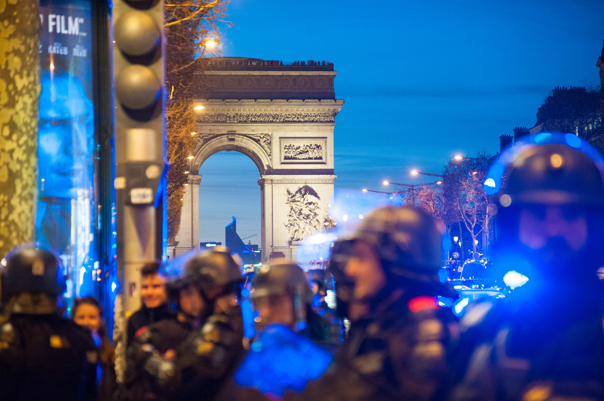Un long cordon de policiers se forme le long des trottoirs sur les Champs. - © Reflets