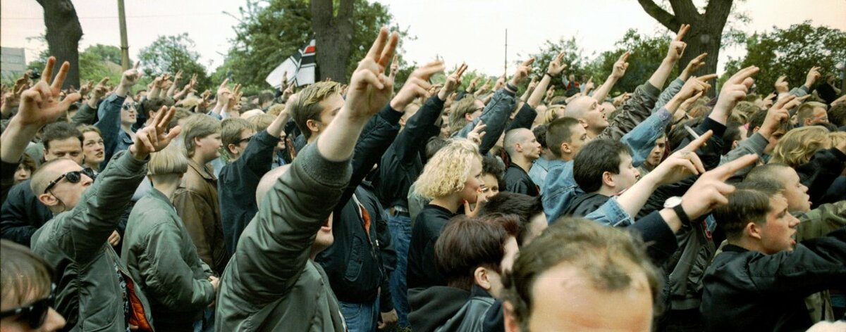 Copie d’écran des archives du bpb.de - Manifestation des radicaux de droite le 14 juin 1991 à Dresde. Des jeunes montrent le « Kuhnengruß », un salut hitlérien modifié, désormais interdit. - bpb.de
