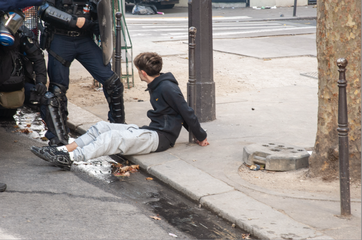 En France, en 2026, on menotte des enfants à des poteaux, assis dans le caniveau - © Reflets