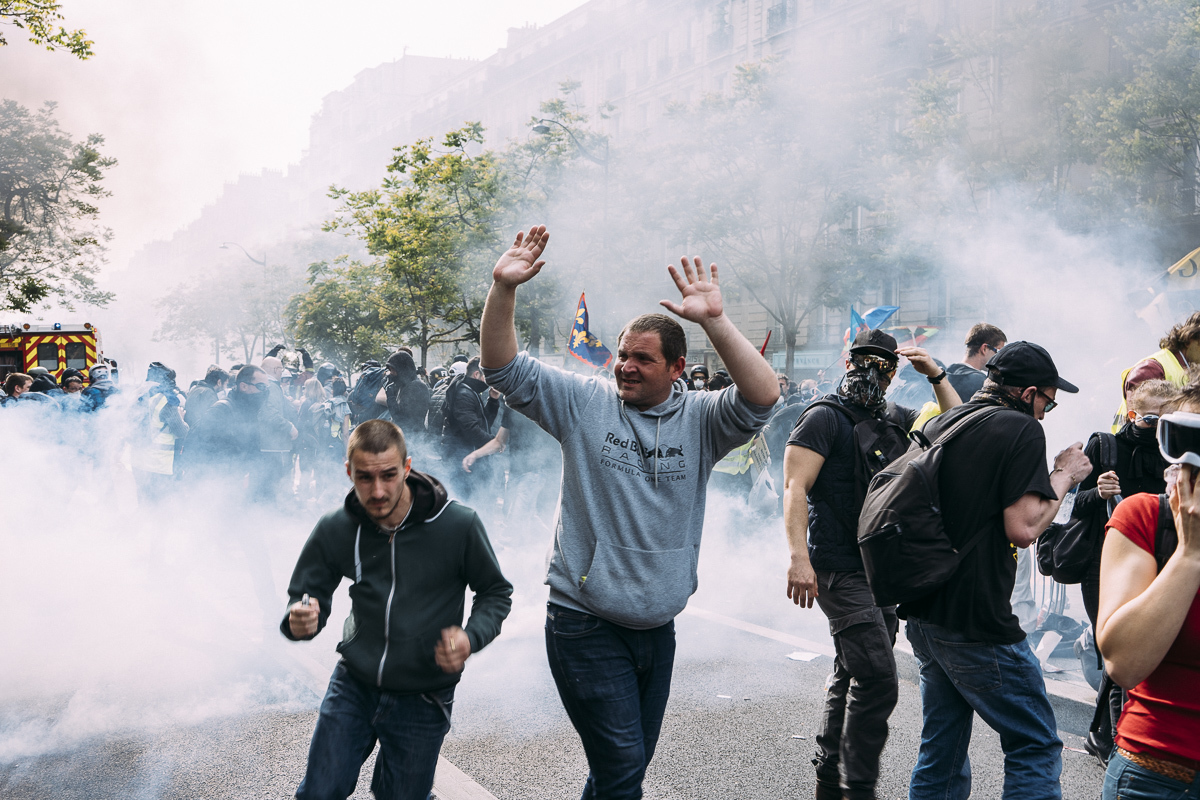 Des manifestants surpris par les gaz lacrymogènes tentent de fuir la manifestation nassée. - © Denis Meyer