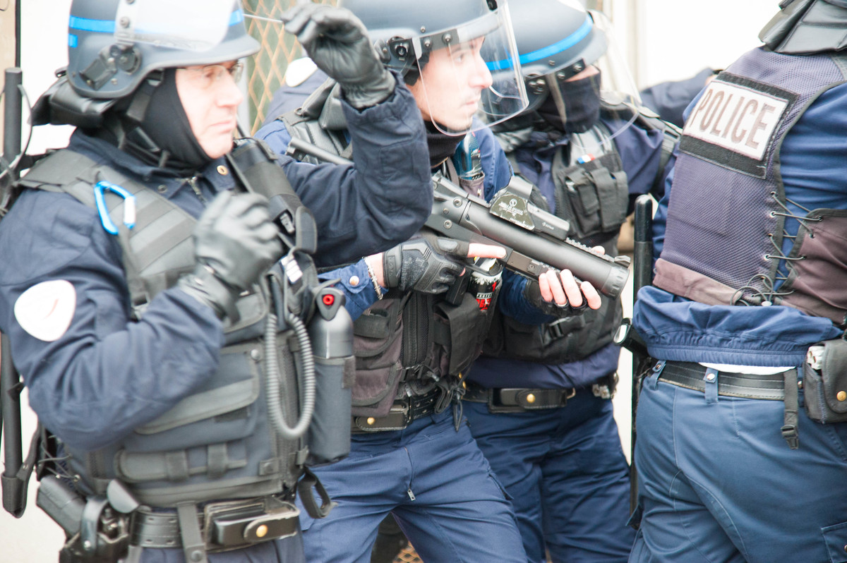 Sur les quais, à côté de la mairie de Paris, quelques policiers sont violemment pris à partie. Premières tensions de la journée. Ils restent relativement calmes en débit de la pluie de bouteilles, de barrières de sécurité et se replient tandis qu'un autre groupe avance sur les quais, avec moult gaz lacrymogènes en appui. - © Reflets