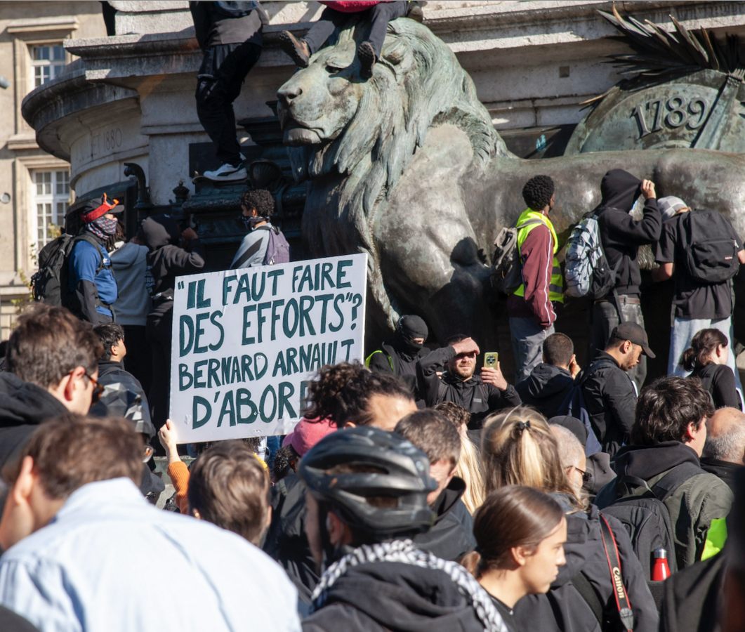 Sur la place, avant les heurts, les pancartes affichent des messages clairs sur les aspirations et les craintes de la jeunesse - © Reflets