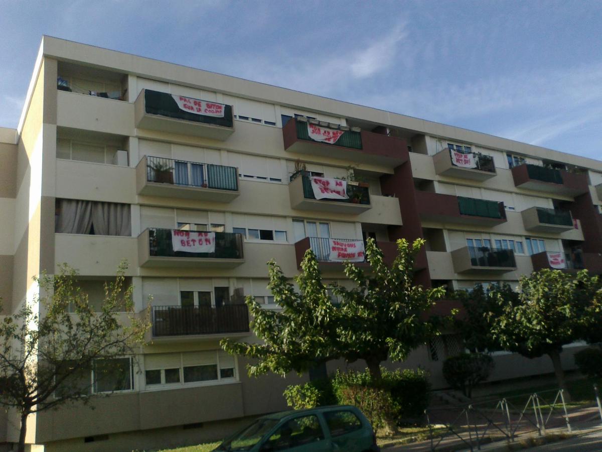 Les habitants du quartier  Las Rébès expriment  sur la façade du bâtiment 10 leur opposition au projet de bétonisation de la colline. - Poumonts Verts